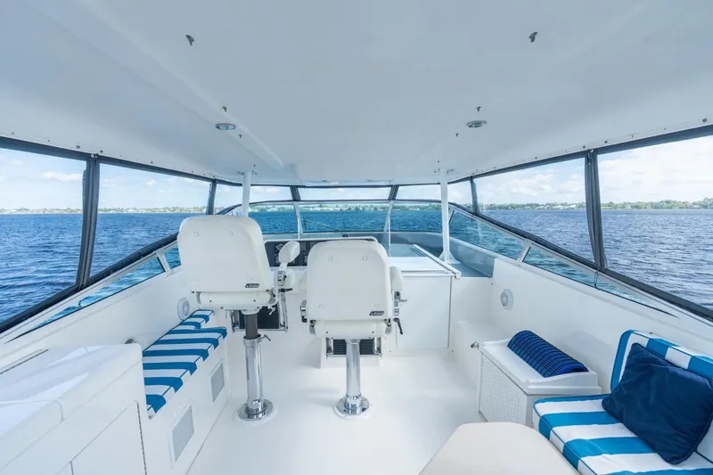 Slide: The Image of 2009 Pacific Mariner 65 Motoryacht helm with ocean view, featuring white and blue seating. - 13