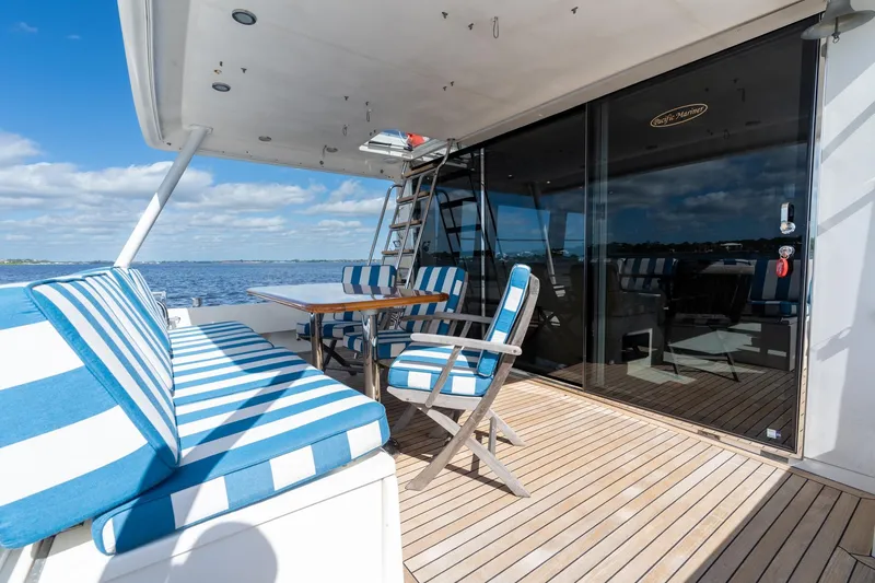 Slide: The Image of 2009 Pacific Mariner 65 Motoryacht deck with striped seating and ocean view. - 24