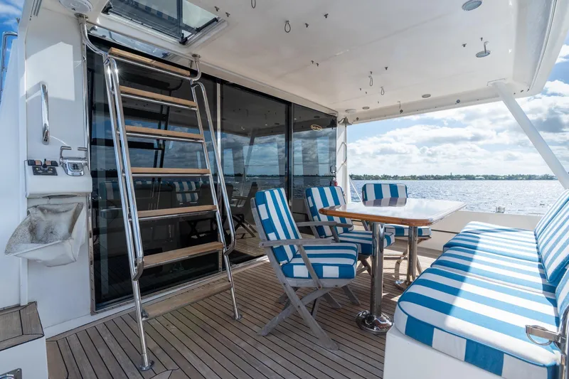 Slide: The Image of 2009 Pacific Mariner 65 Motoryacht deck with striped seating and ocean view. - 25