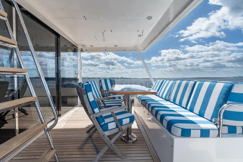 Slide: The Image of 2009 Pacific Mariner 65 Motoryacht deck with striped seating and ocean view. - 27