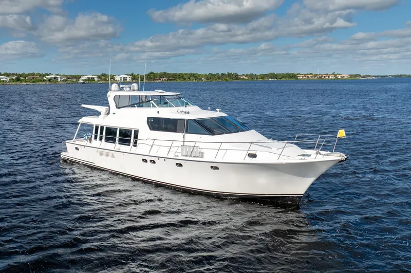 Slide: The Image of 2009 Pacific Mariner 65 Motoryacht cruising on a serene blue lake under a partly cloudy sky. - 7