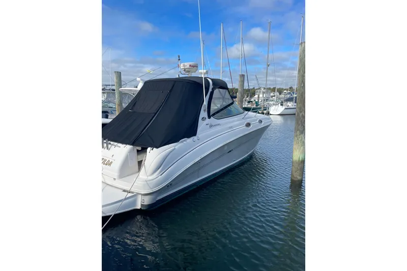 The Image of 2006 Sea Ray Sundancer 280 docked at marina, featuring sleek design and black cover. - 0