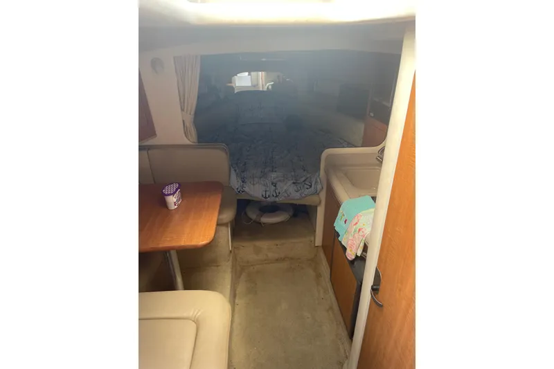Slide: The Image of 2006 Sea Ray Sundancer 280 cabin interior with seating, table, and bed. - 13