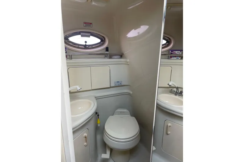 Slide: The Image of 2006 Sea Ray Sundancer 280 bathroom with sink, toilet, and porthole window. - 15