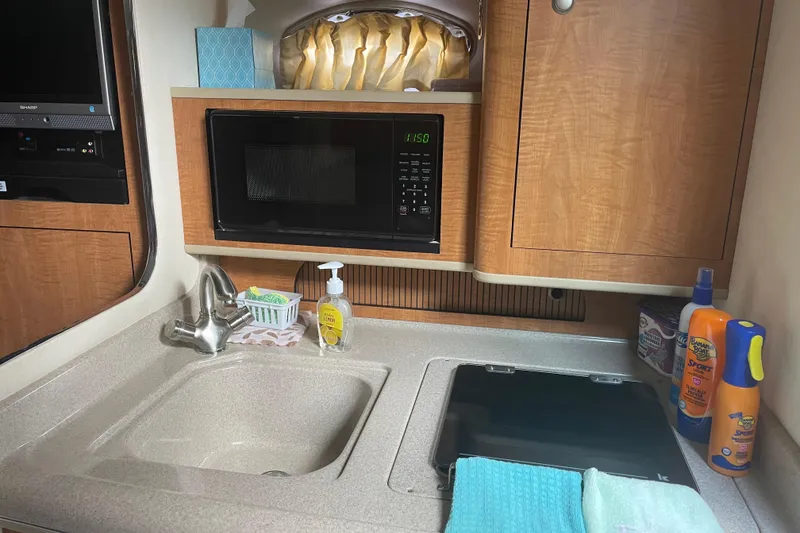 Slide: The Image of Compact kitchen area in a 2006 Sea Ray Sundancer 280 boat with sink and microwave. - 16