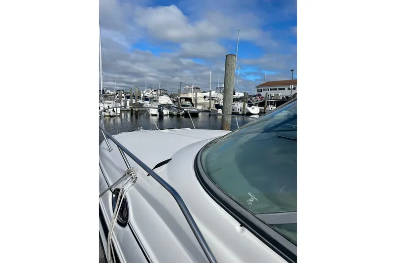 Slide: The Image of 2006 Sea Ray Sundancer 280 docked at a marina under a cloudy sky. - 2