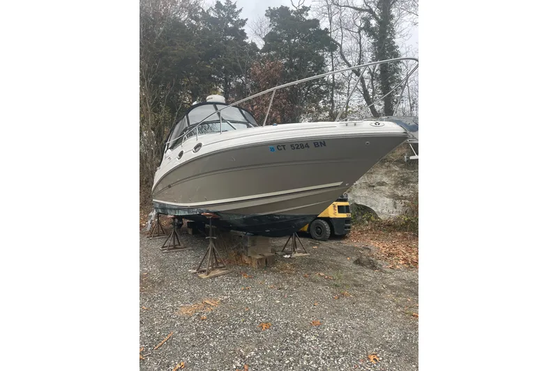 Slide: The Image of 2006 Sea Ray Sundancer 280 boat on stands, surrounded by trees and gravel. - 5