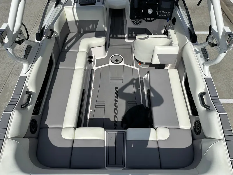 Slide: The Image of 2024 Moomba Max boat interior with gray and white seating, steering wheel, and control panel. - 14