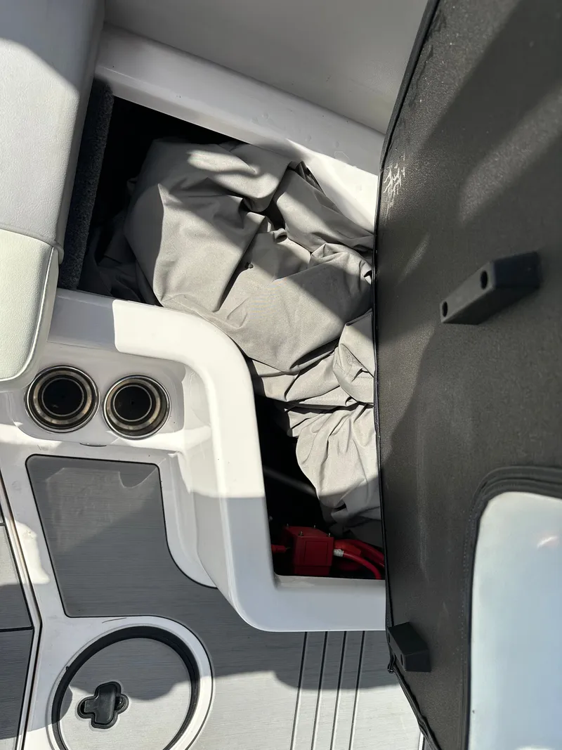 Slide: The Image of 2024 Moomba Max boat storage compartment with cover and cup holders. - 17