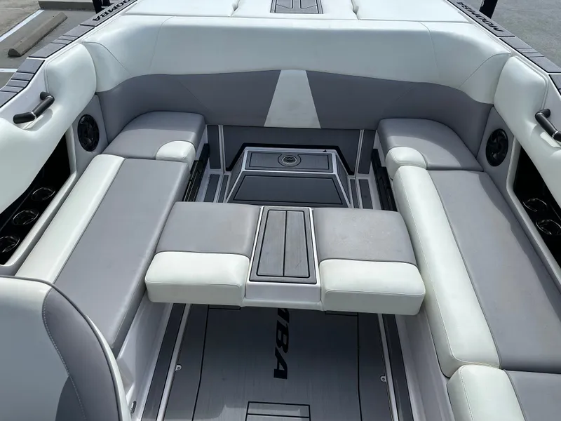 Slide: The Image of 2024 Moomba Max boat interior with gray and white seating, featuring cup holders and speakers. - 20