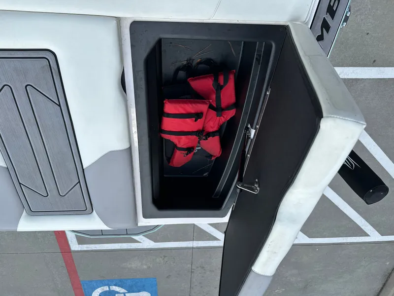 Slide: The Image of 2024 Moomba Max boat storage compartment with red life jacket inside. - 22