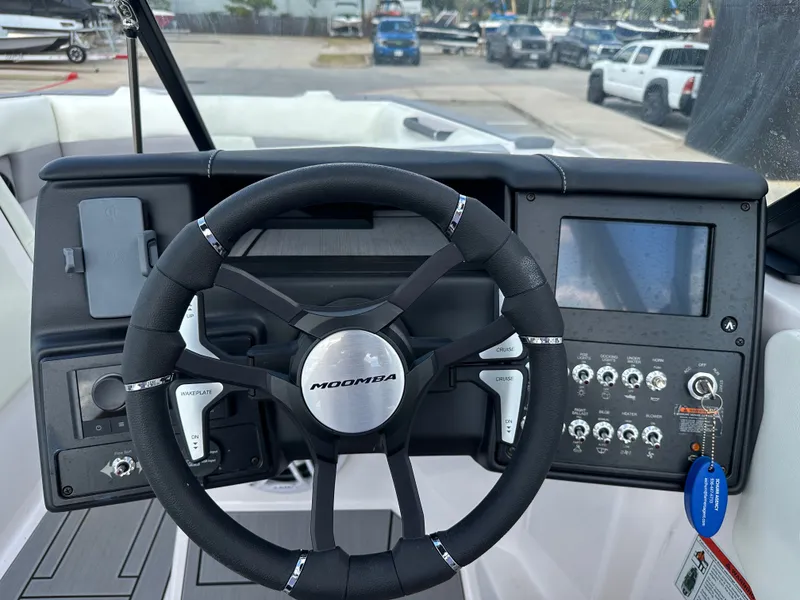 Slide: The Image of 2024 Moomba Max boat dashboard with steering wheel and control panel. - 26