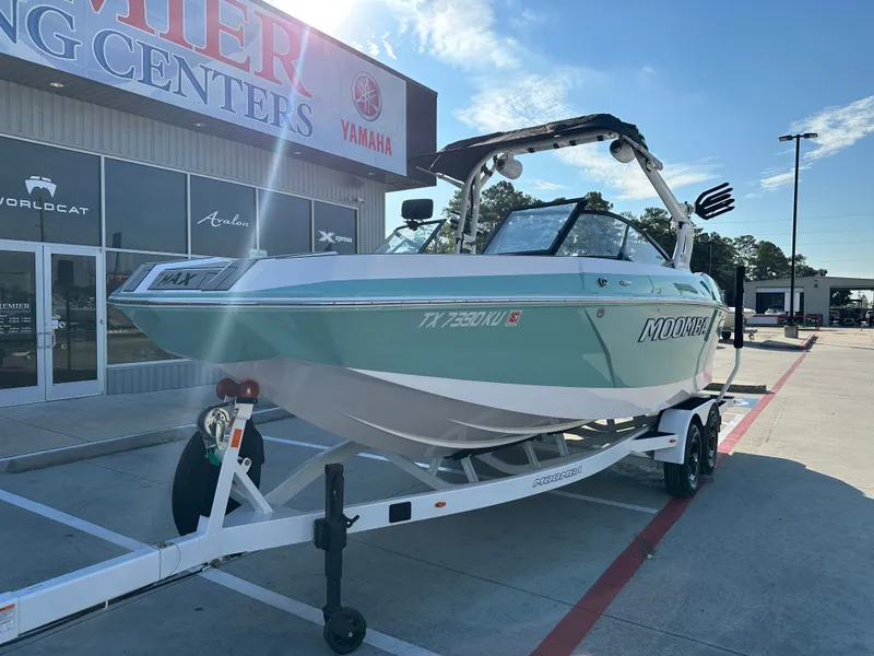 Slide: The Image of 2024 Moomba Max boat on trailer outside dealership, sunny day. - 3