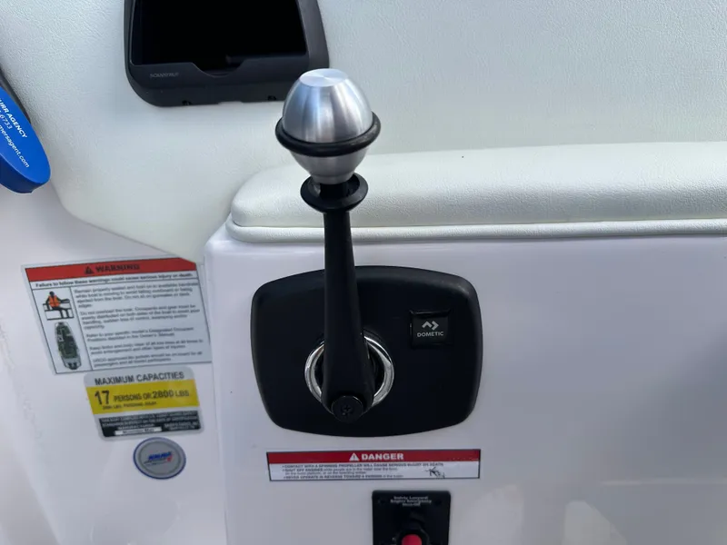 Slide: The Image of 2024 Moomba Max boat control panel with lever and warning labels. - 33