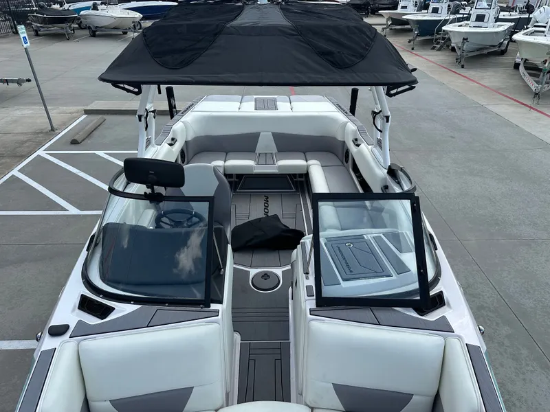 Slide: The Image of 2024 Moomba Max boat with black canopy, spacious seating, and modern design in a marina setting. - 38