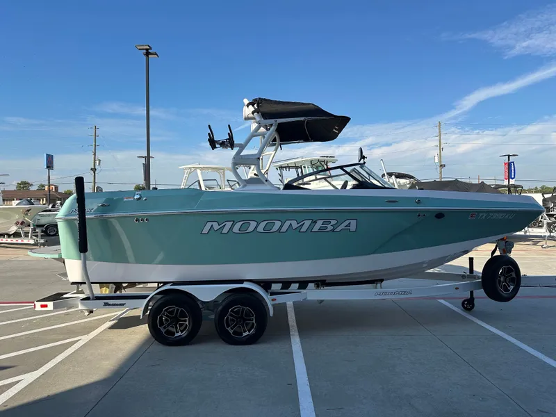 Slide: The Image of 2024 Moomba Max boat on trailer in parking lot, clear sky background. - 7