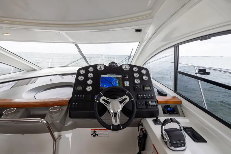 Slide: The Image of Helm of 2014 Beneteau Gran Turismo 44 yacht with navigation controls and sea view. - 13