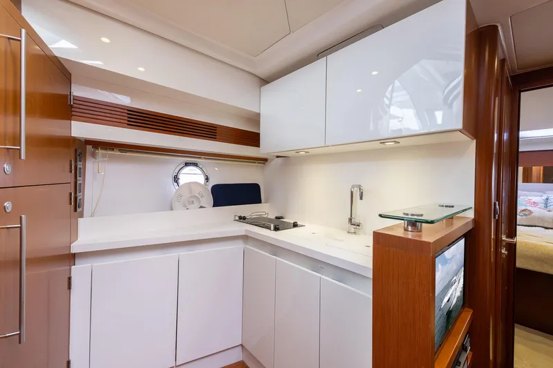 Slide: The Image of 2014 Beneteau Gran Turismo 44 yacht kitchen with modern white cabinetry and sleek design. - 18