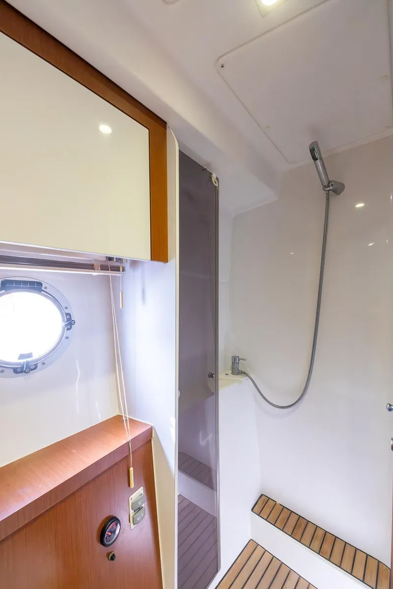 Slide: The Image of 2014 Beneteau Gran Turismo 44 yacht bathroom with shower and wooden accents. - 23