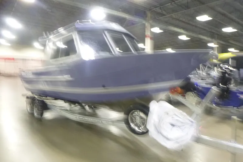 Slide: The Image of Blurry image of a 2026 KingFisher 2425 Escape HT boat on display indoors. - 11
