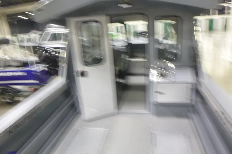 Slide: The Image of Blurry interior view of a 2026 KingFisher 2425 Escape HT boat at a showroom. - 14