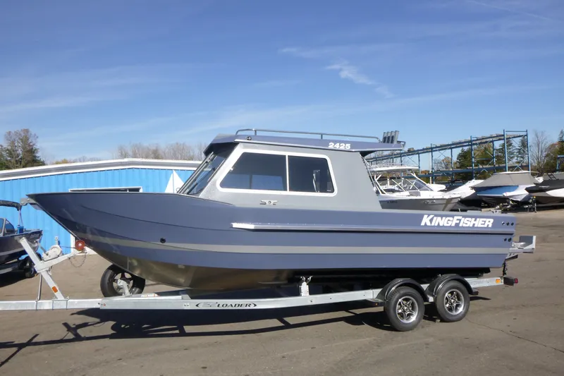 The Image of 2026 KingFisher 2425 Escape HT boat on trailer, parked outdoors near blue building. - 0