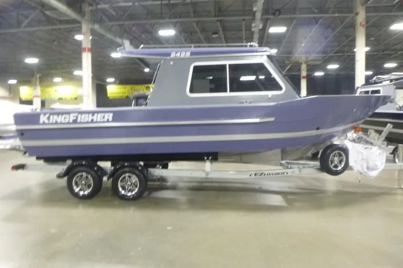 The Image of 2026 KingFisher 2425 Escape HT boat on trailer in indoor showroom. - 9