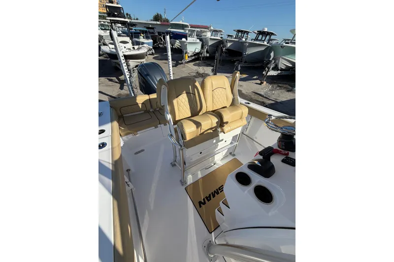 Slide: The Image of 2023 Sportsman Heritage 241 Center Console boat interior with tan seating and control panel. - 5