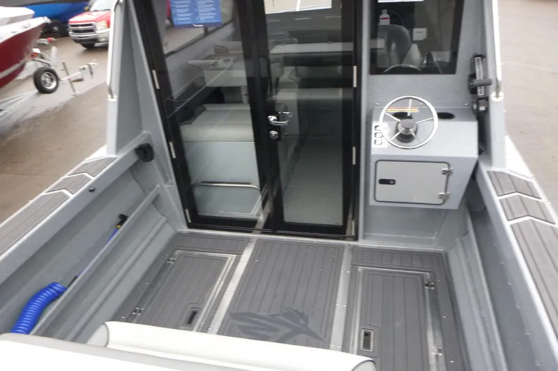 Slide: The Image of 2026 KingFisher 25 XAC boat interior with steering wheel and seating area. - 10