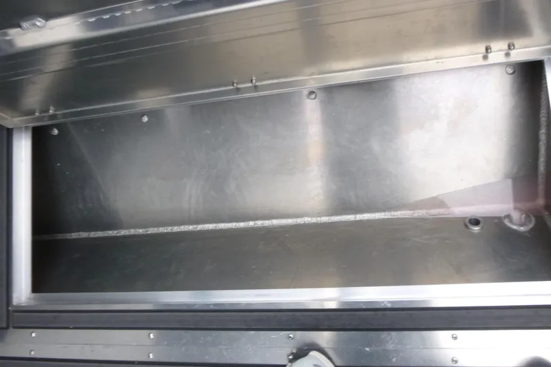 Slide: The Image of Storage compartment of 2026 KingFisher 25 XAC boat, featuring durable metal construction. - 16