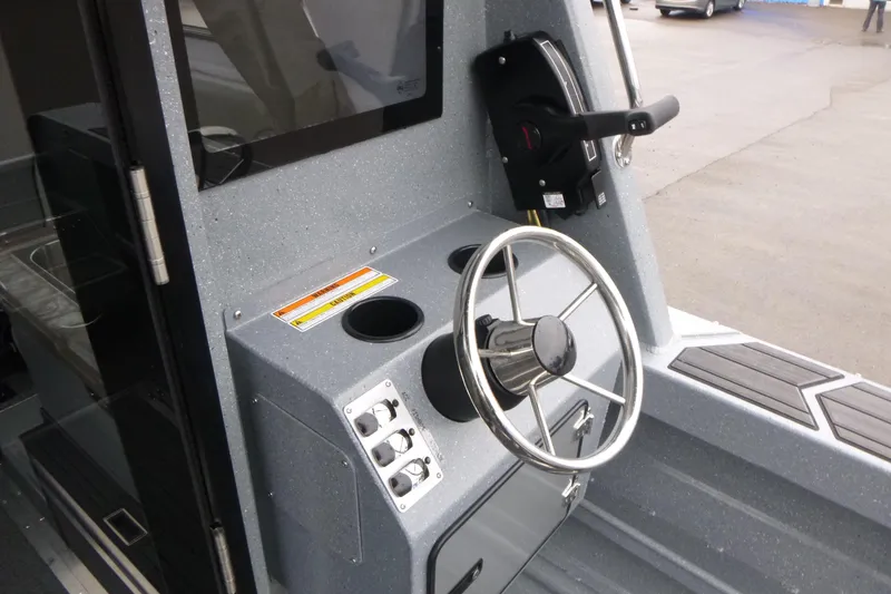 Slide: The Image of 2026 KingFisher 25 XAC boat helm with steering wheel and control panel. - 18