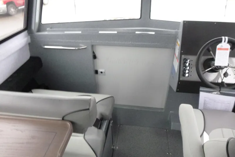 Slide: The Image of Interior of 2026 KingFisher 25 XAC boat, featuring steering wheel and seating area. - 29
