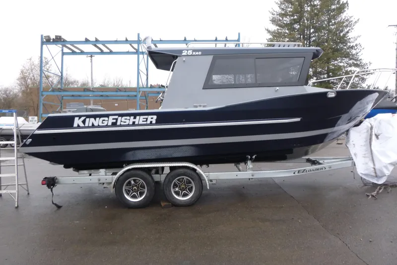 The Image of 2026 KingFisher 25 XAC boat on trailer, parked outdoors, side view. - 4