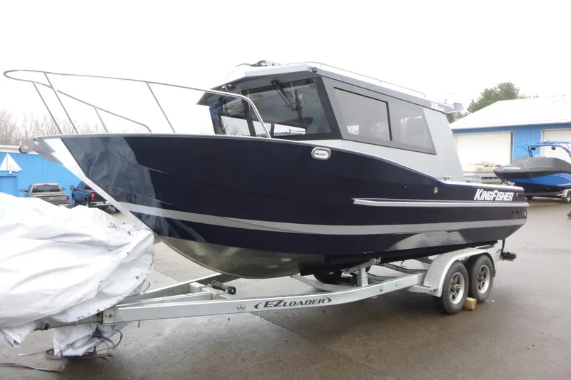 Slide: The Image of 2026 KingFisher 25 XAC boat on trailer, parked outdoors. - 8