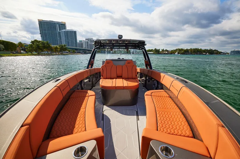 Slide: The Image of Luxurious Midnight Express 37' Open boat with orange seating, cruising on a scenic waterway. - 7