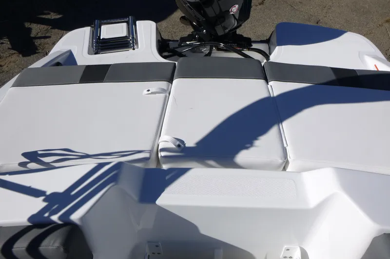 Slide: The Image of 2026 Tahoe T18 boat interior with cushioned seating and motor. - 12