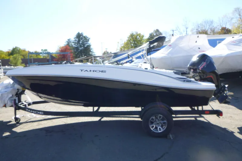 Slide: The Image of 2026 Tahoe T18 boat on trailer, parked outdoors, with outboard motor. - 3