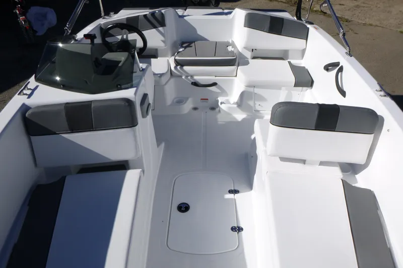 Slide: The Image of 2026 Tahoe T18 boat interior with white and gray seating, steering wheel, and spacious layout. - 5