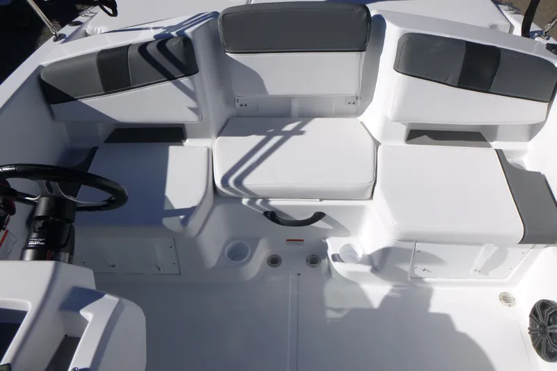Slide: The Image of 2026 Tahoe T18 boat interior with white and gray seating, steering wheel, and storage compartments. - 8