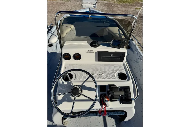 Slide: The Image of 2001 Blue Wave 220 Classic boat dashboard with steering wheel and controls. - 10