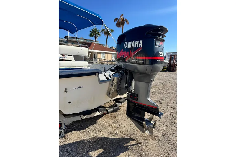 Slide: The Image of 2001 Blue Wave 220 Classic boat with Yamaha outboard motor, parked outdoors. - 24