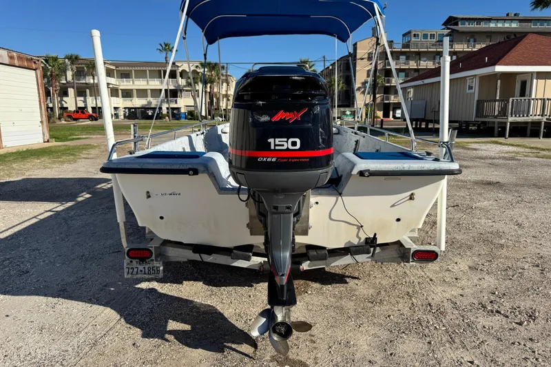 Slide: The Image of 2001 Blue Wave 220 Classic boat with Yamaha 150 outboard motor, parked outdoors. - 25