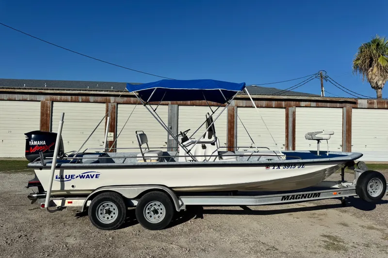 Slide: The Image of 2001 Blue Wave 220 Classic boat on trailer, with Yamaha engine, parked outdoors. - 3