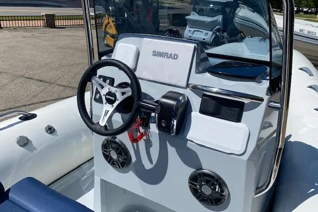 Slide: The Image of 2026 Brig Eagle 6 boat dashboard with Simrad navigation system and steering wheel. - 4