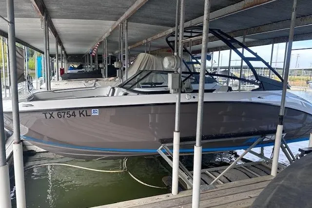 The Image of 2022 Yamaha Boats AR250 docked in a covered marina, side view. - 0