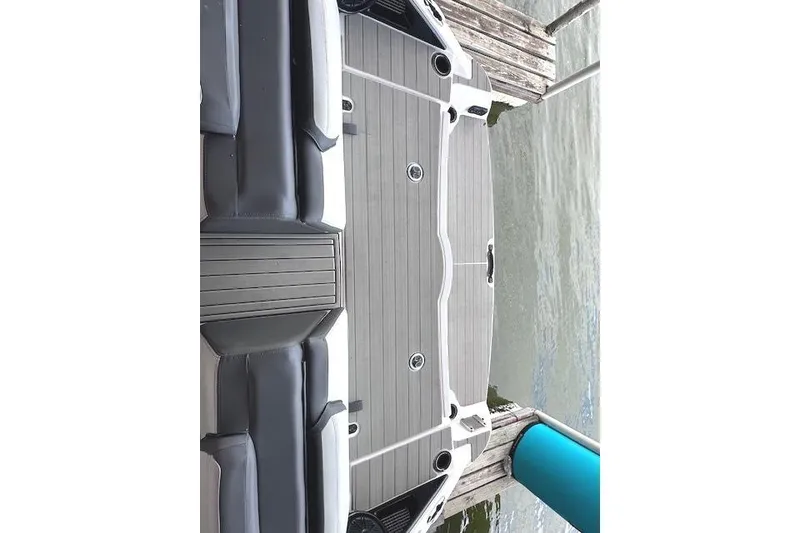 Slide: The Image of 2022 Yamaha Boats AR250 deck view at dock, featuring sleek seating and modern design. - 25