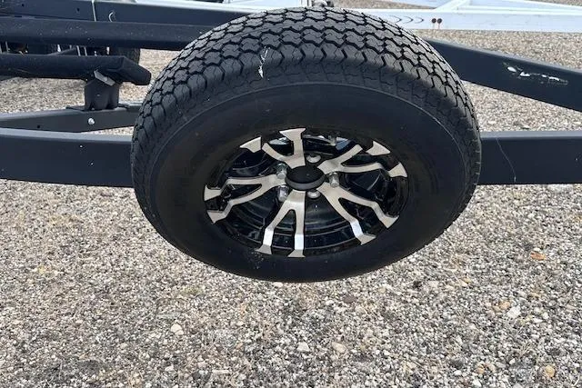 Slide: The Image of 2022 Yamaha Boats AR250 trailer wheel on gravel surface. - 43