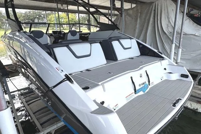 Slide: The Image of 2022 Yamaha Boats AR250 in dock, showcasing sleek design and spacious seating. - 6