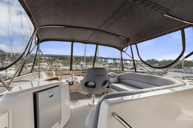 Slide: The Image of 2008 Meridian 408 Motoryacht interior with helm, seating, and marina view. - 13