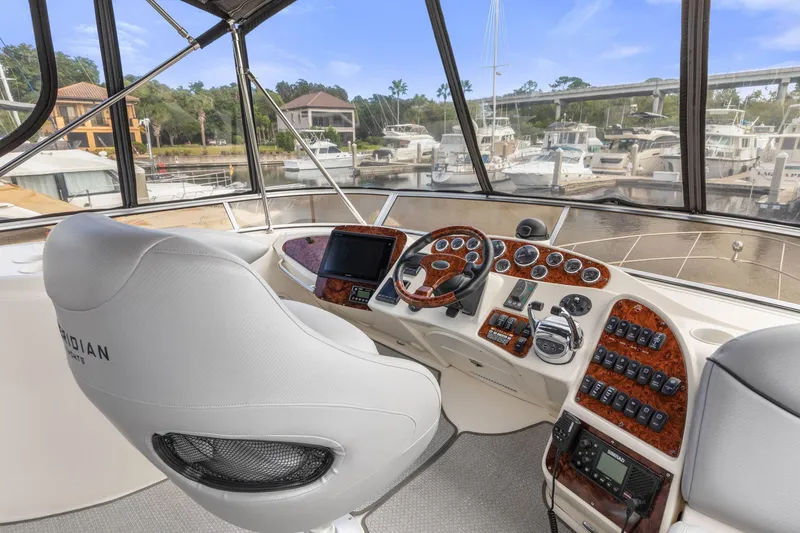 Slide: The Image of 2008 Meridian 408 Motoryacht helm with luxurious controls and marina view. - 17